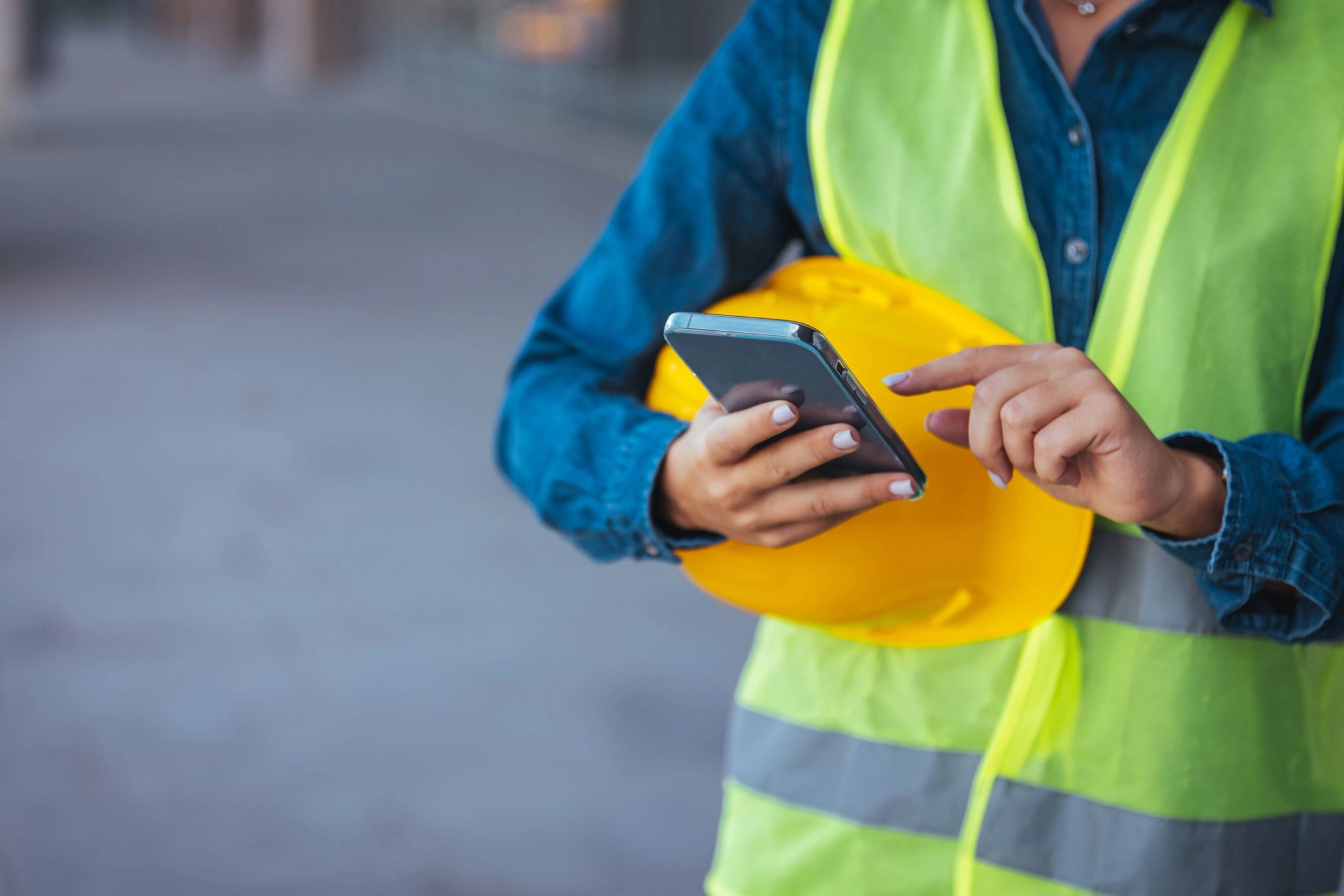 Tradesperson using a smartphone on a job site