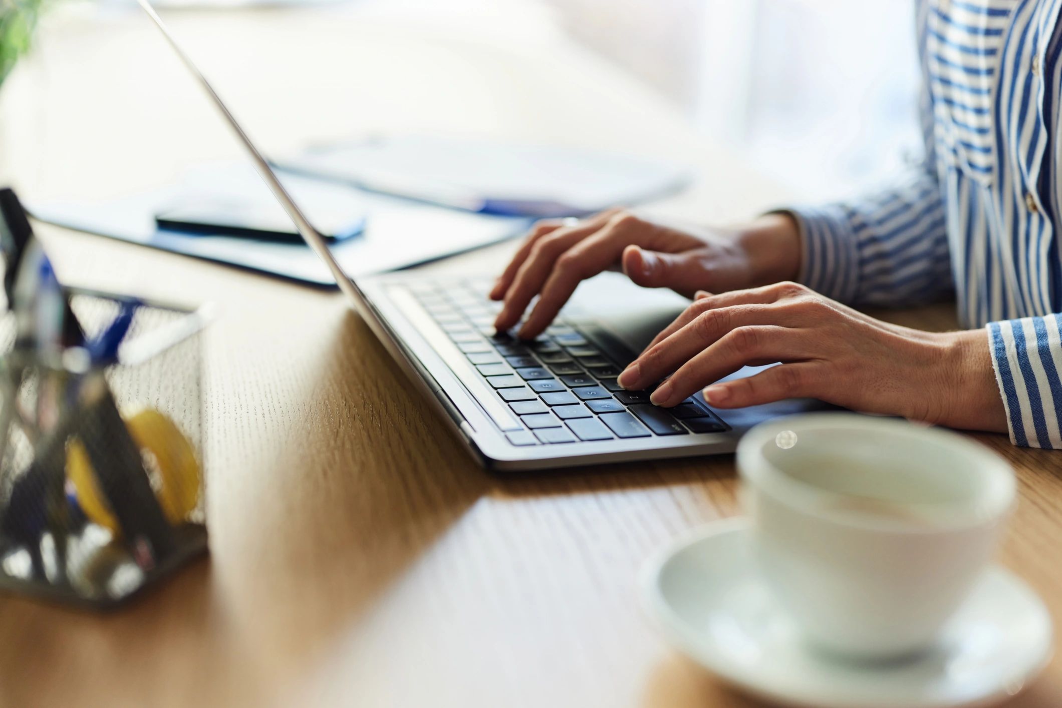 Office worker typing on a laptop in a modern workspace